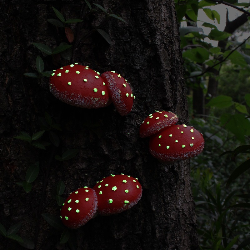 Red mushroom clusters on a tree trunk at dusk with glowing spots