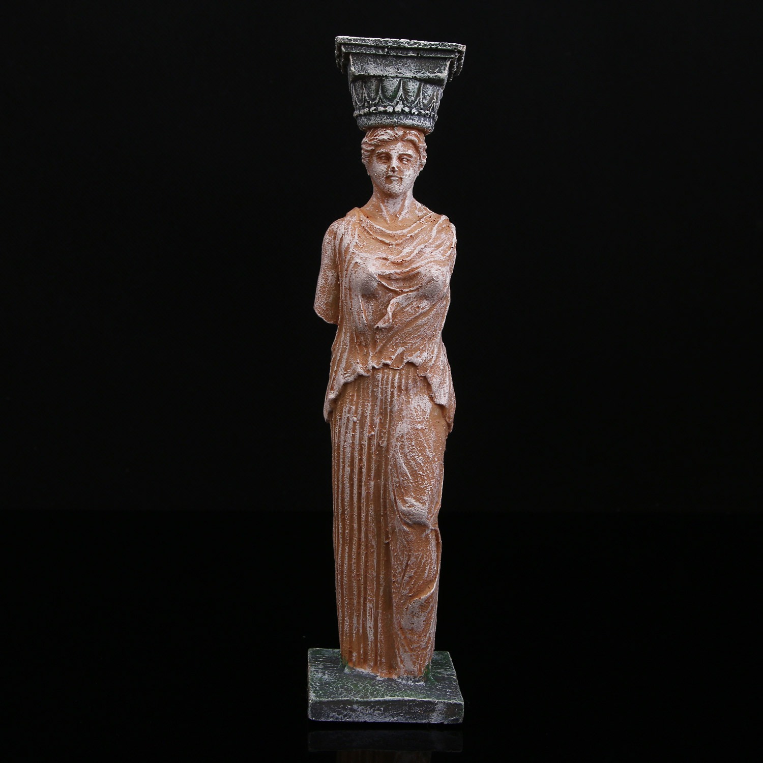 Weathered goddess statue with broken arm detail in soft light