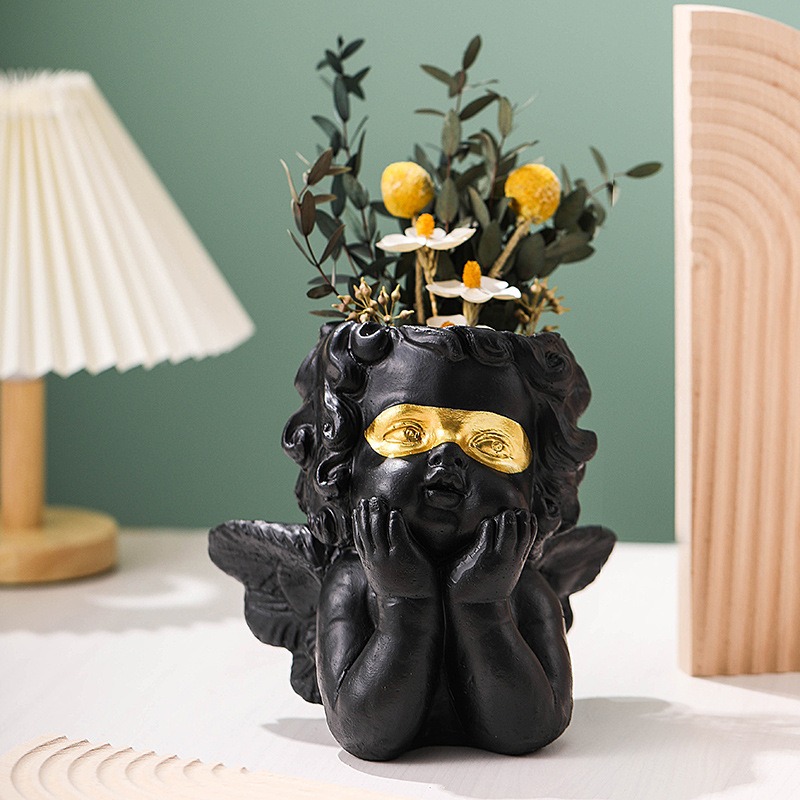 Gold cherub planter styled on a shelf in a bright room