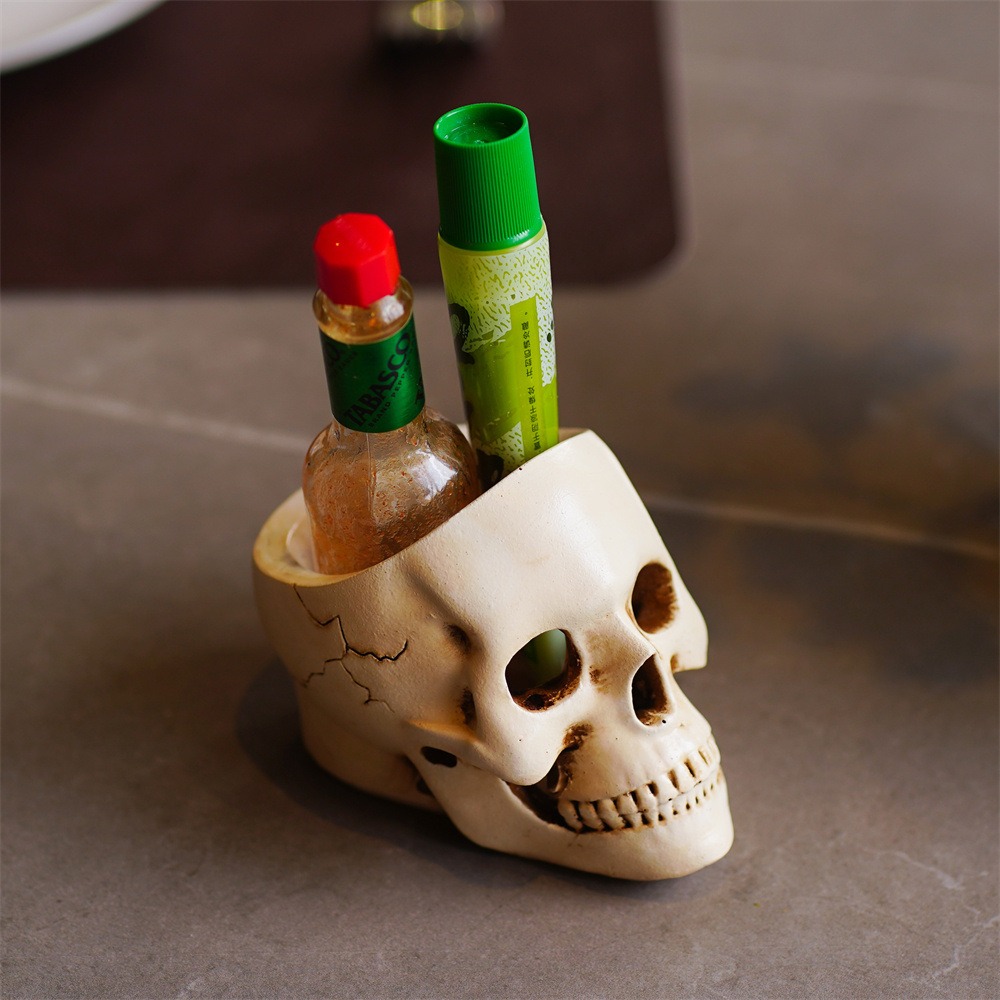 Skull organizer holding a hot sauce bottle and a lip balm tube