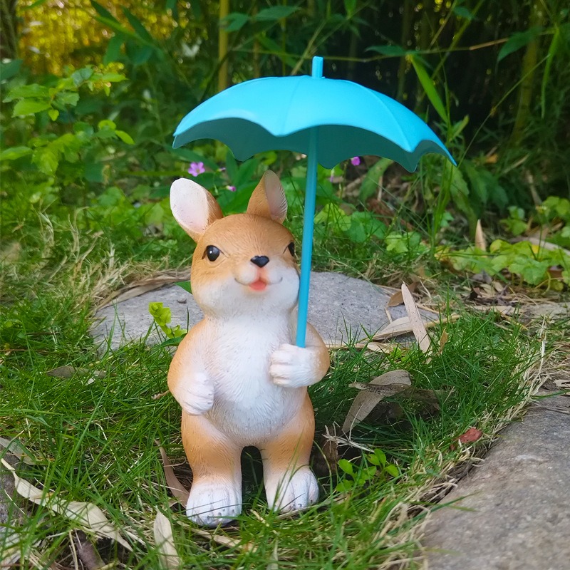 Bunny ornament standing on grass with bamboo and plants behind it