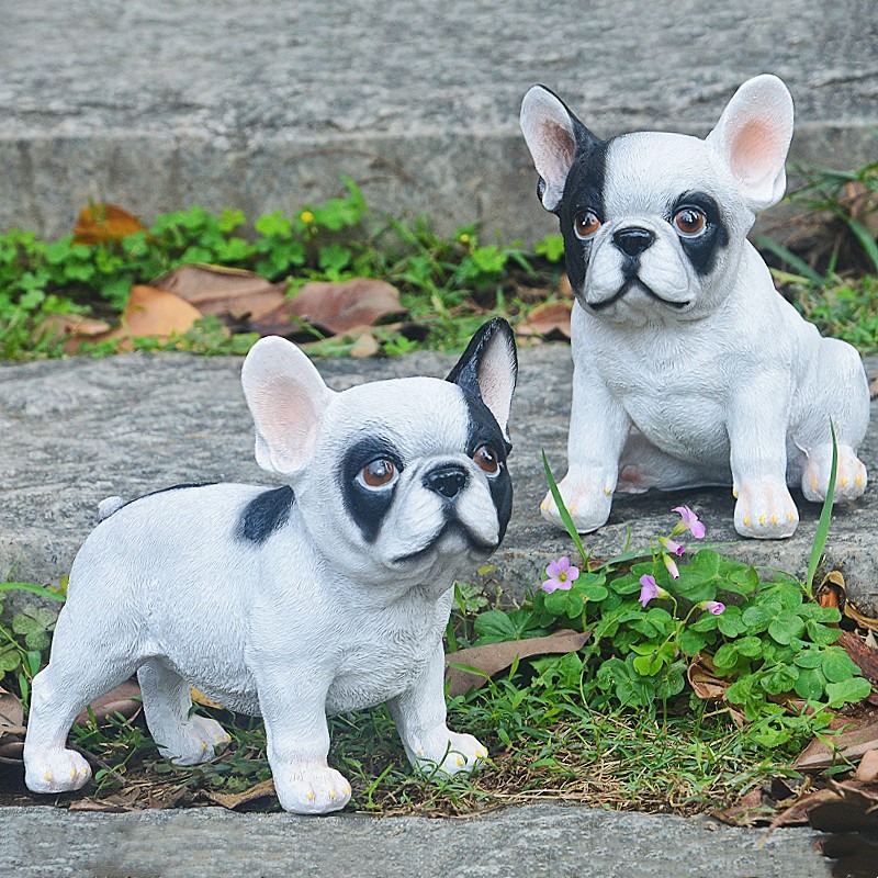 Standing and sitting bulldog figurines placed among outdoor stone steps