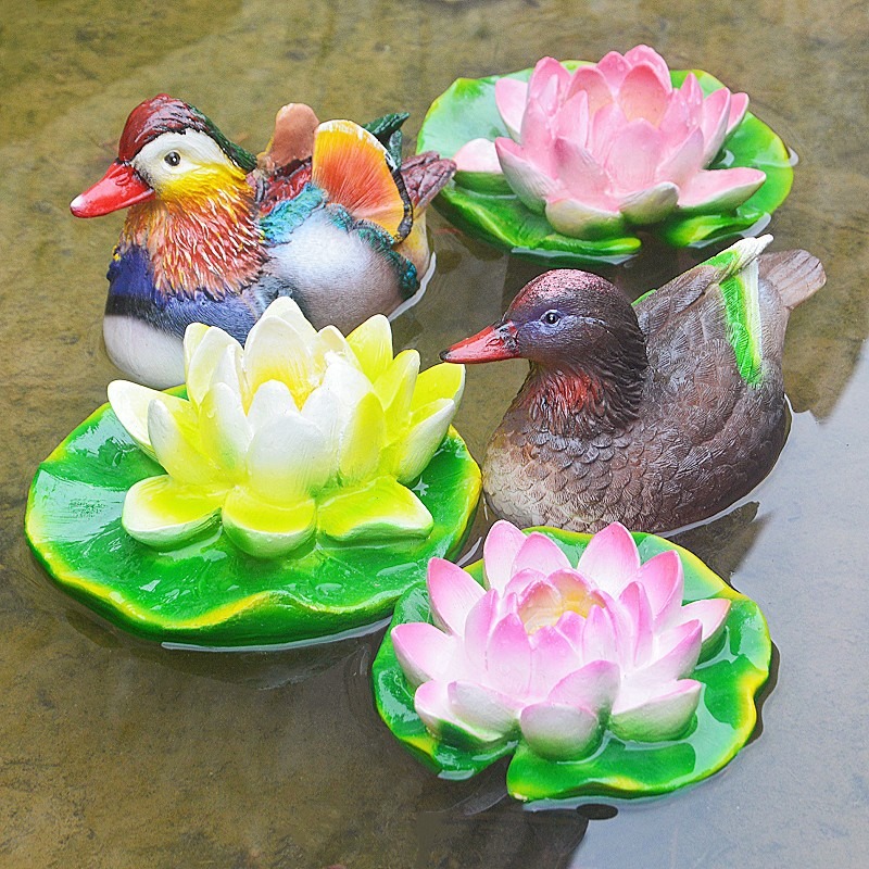 Mandarin duck decor settled on pond water beside the garden edge
