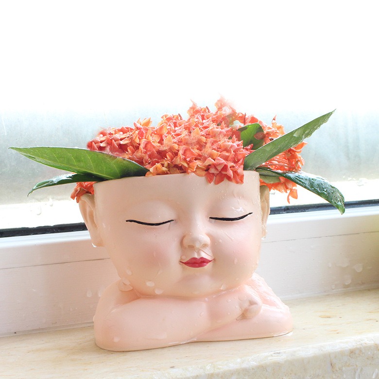Sleeping baby face planter with flowers and leaves in the crown