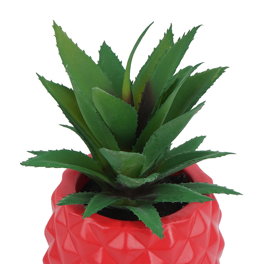 Close-up of artificial agave leaves with serrated edges rising from red pot