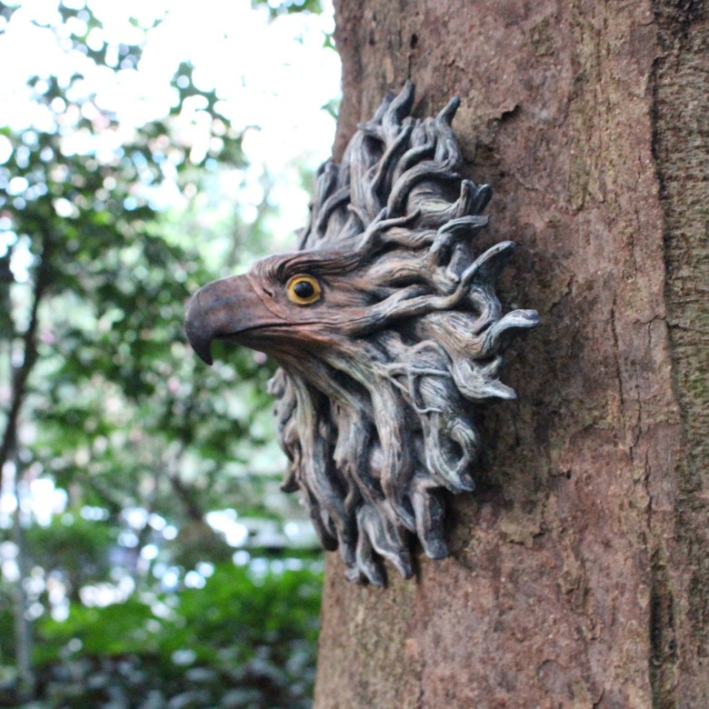Side profile of eagle head mounted on tree trunk