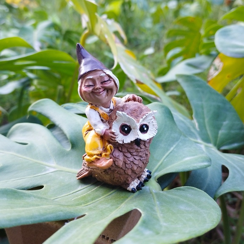Garden figure placed among plants along a walking path