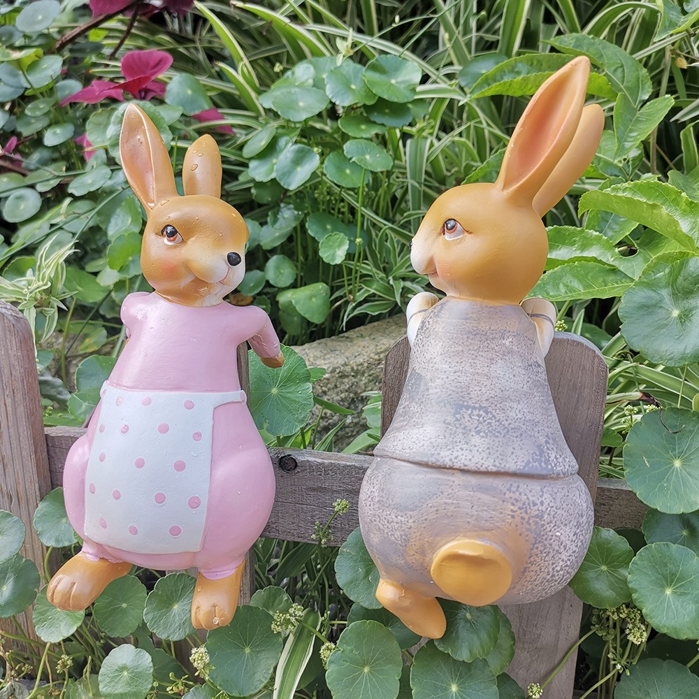 Pink rabbit and grey rabbit figurines resting in a foam tray