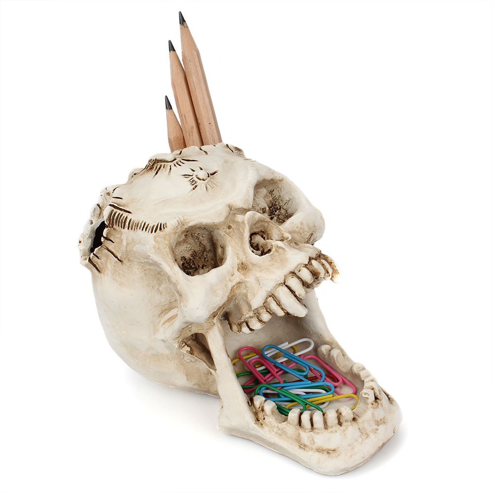 Skull desk organizer holding pencils in the crown and clips in the jaw