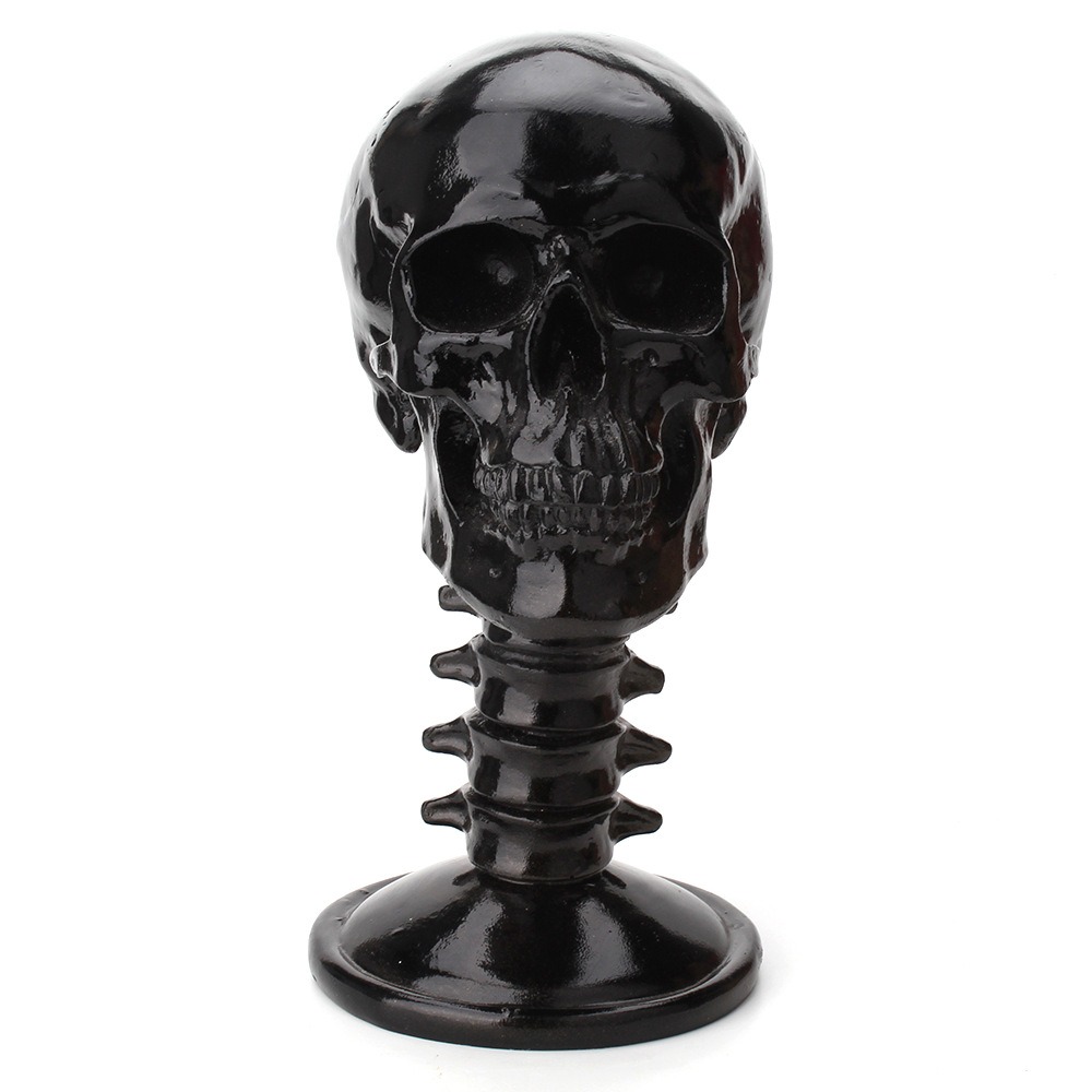 Front view of black skull stand with ribbed neck on a pale surface