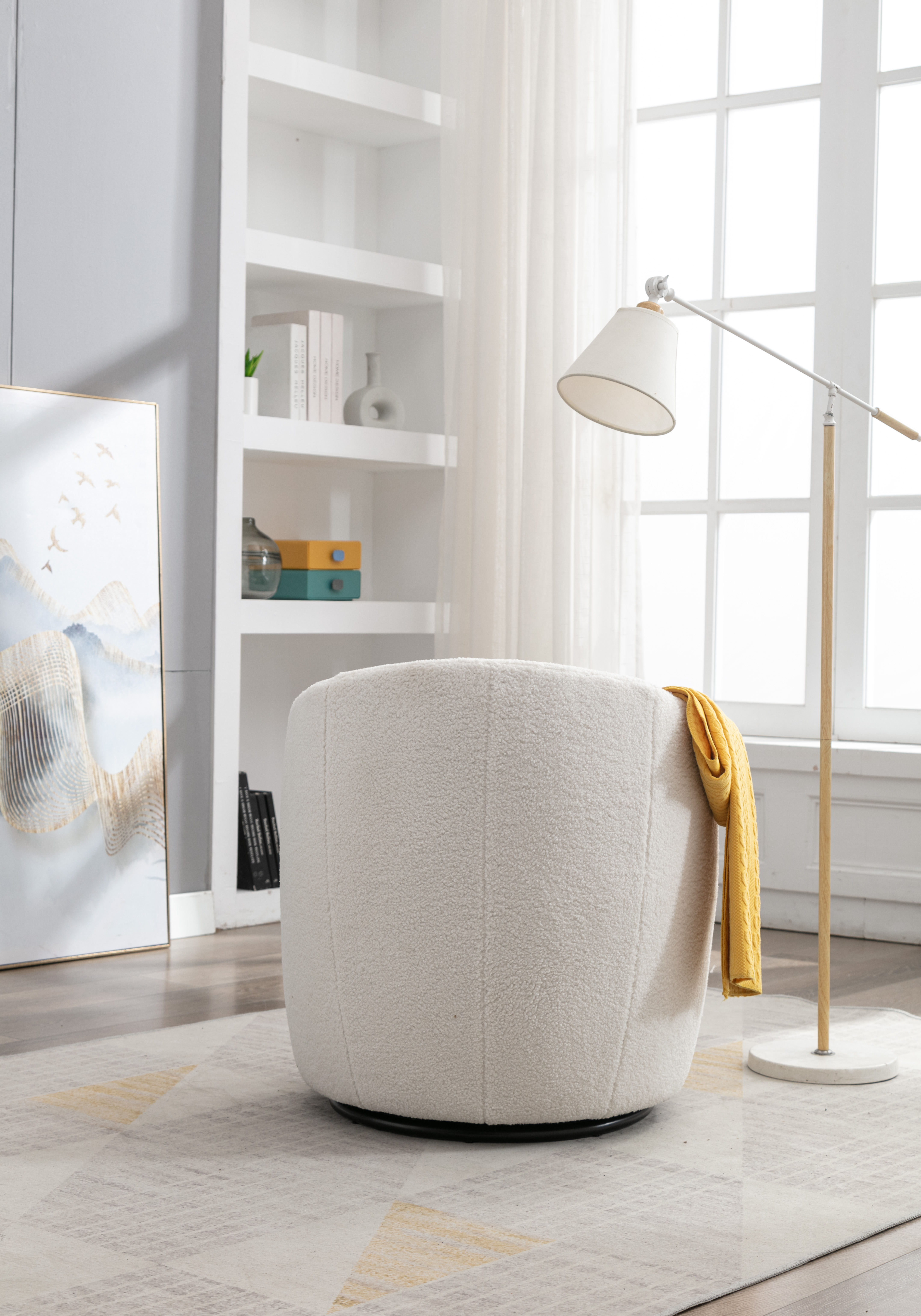 Ivory boucle swivel chair in a living room beside a floor lamp