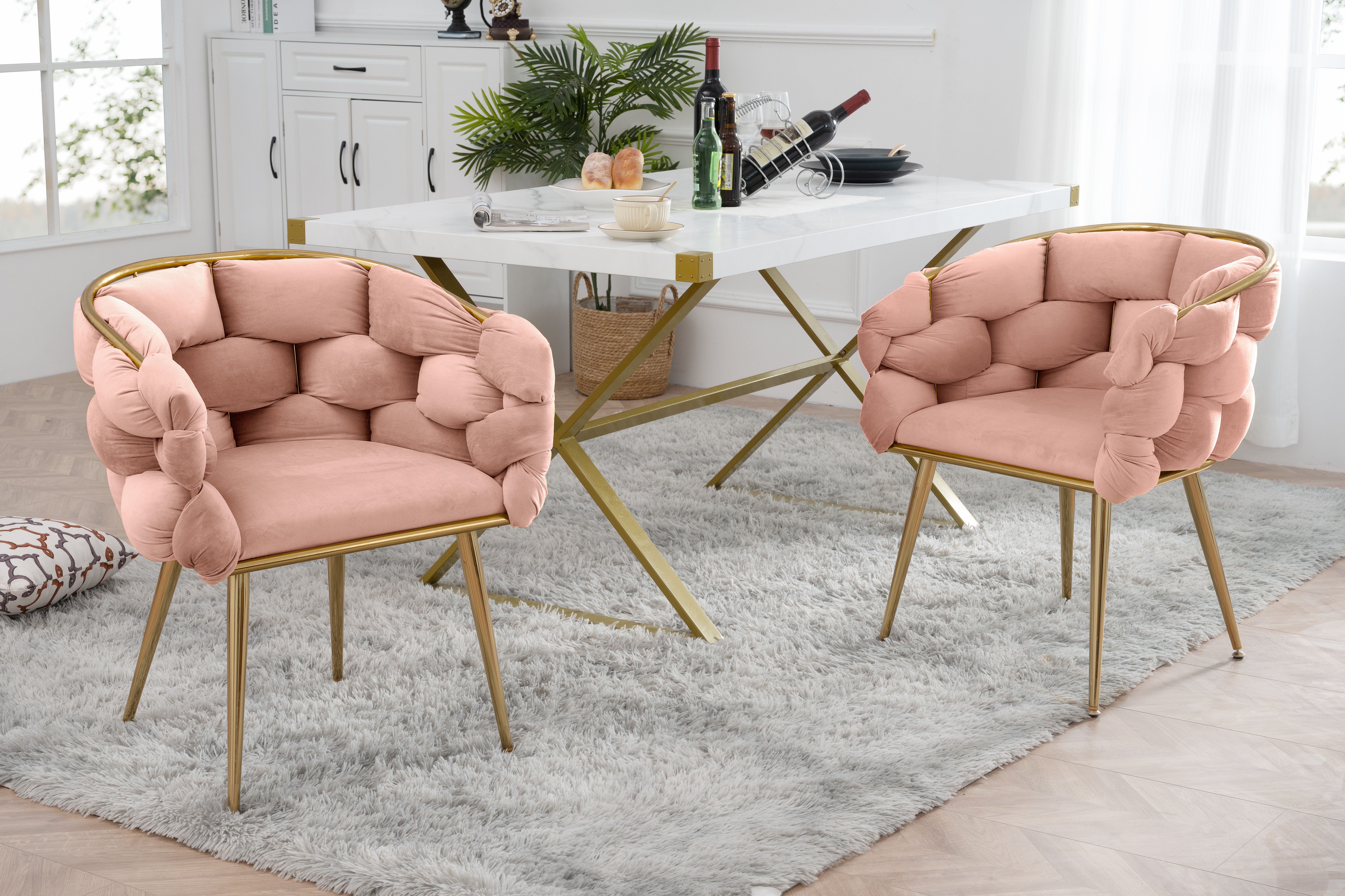 Two pink tufted chairs at a dining table on a grey rug