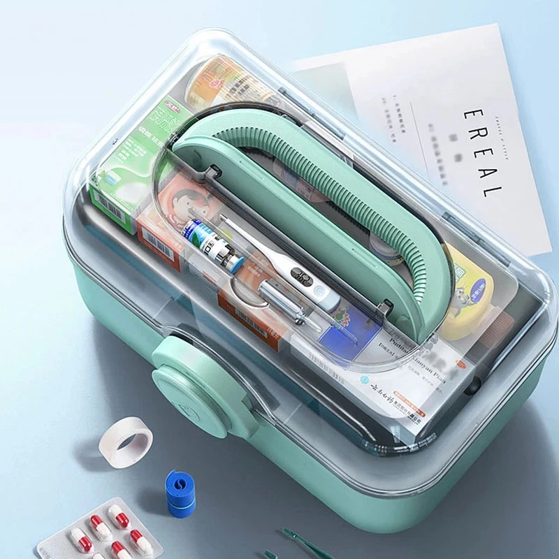 Top view of mint-green organizer with clear lid, thermometer, tape and pills
