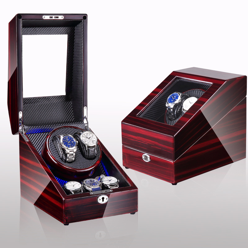 Watches seated in cradles inside an open wooden winder