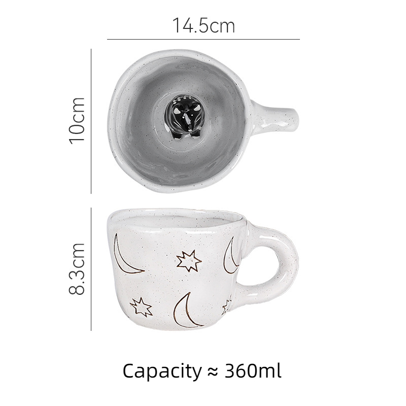 Grey-white mug with black cat figure and moon and star carvings