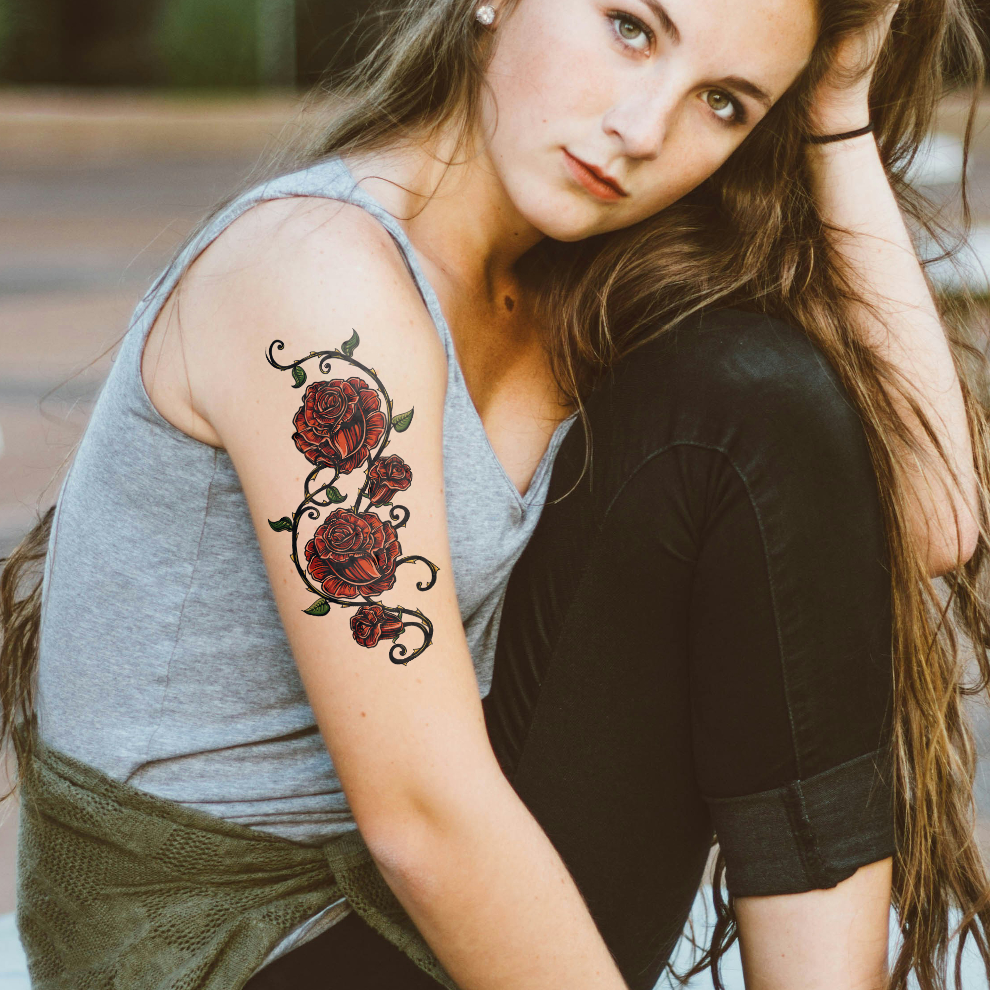 Woman with maroon rose temporary tattoo on arm, ideal for fashion events