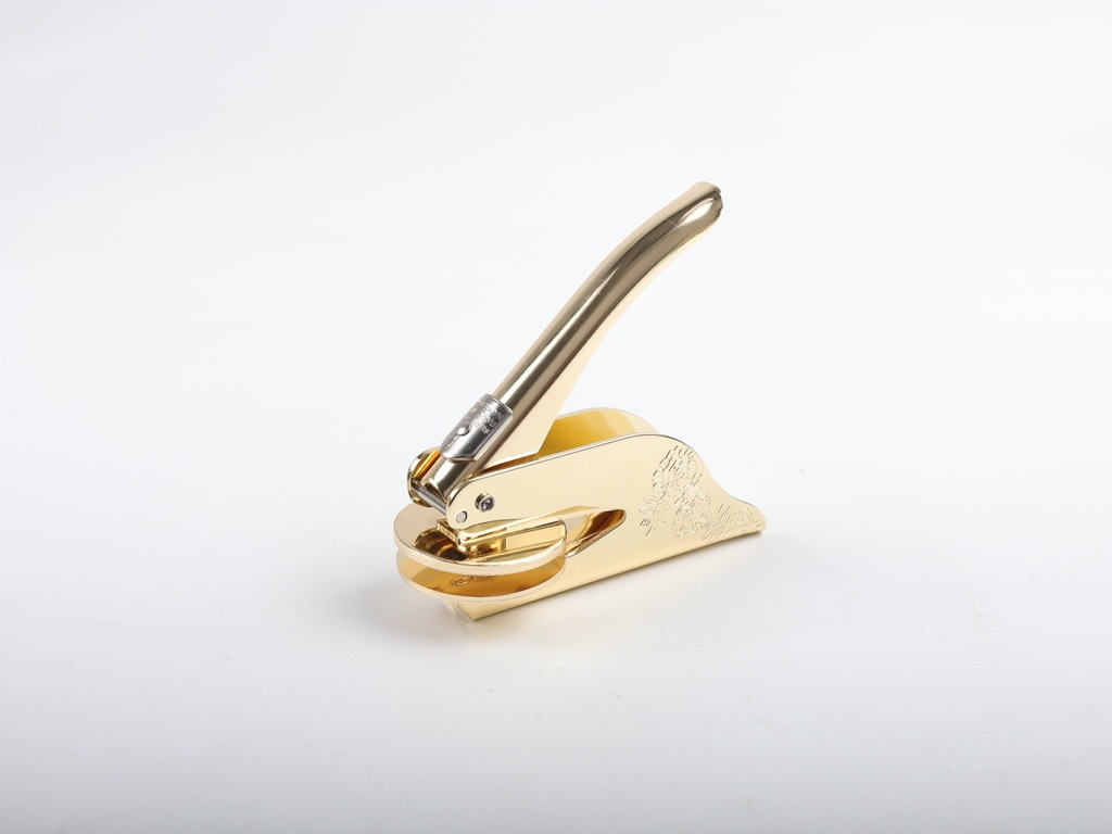 Polished rose gold press with floral engraving on the base
