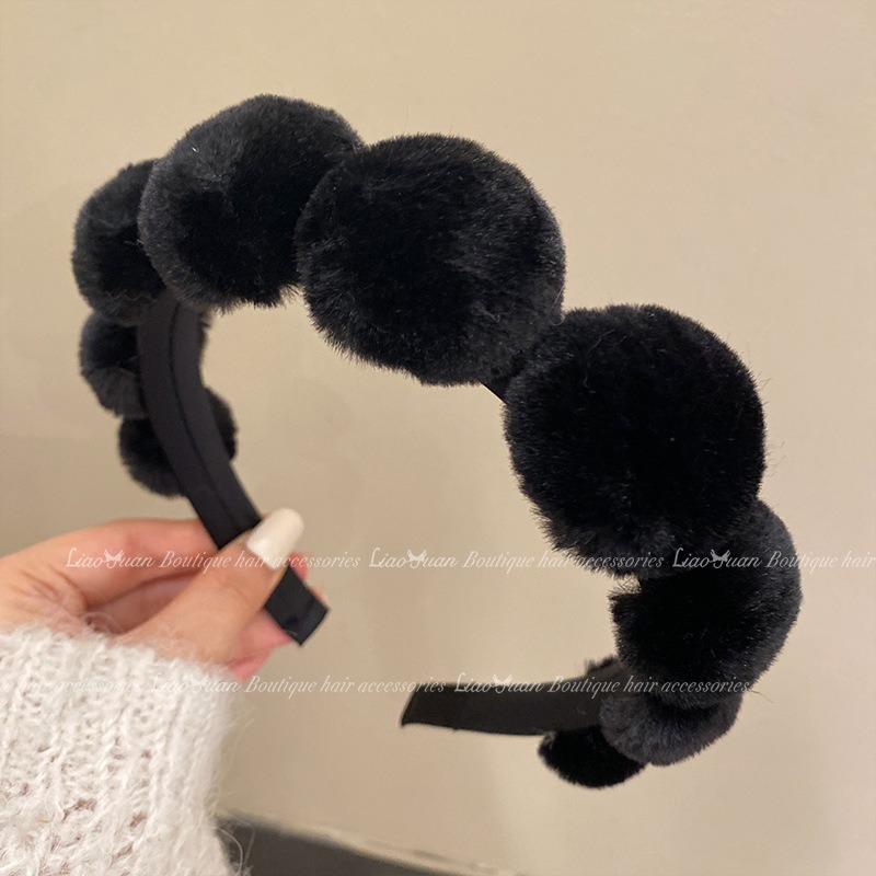 Black headband with dense faux-fur pom-poms