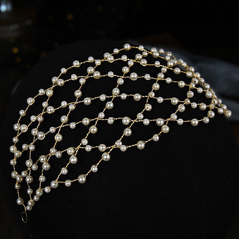 Layered pearl strands over a dark display form