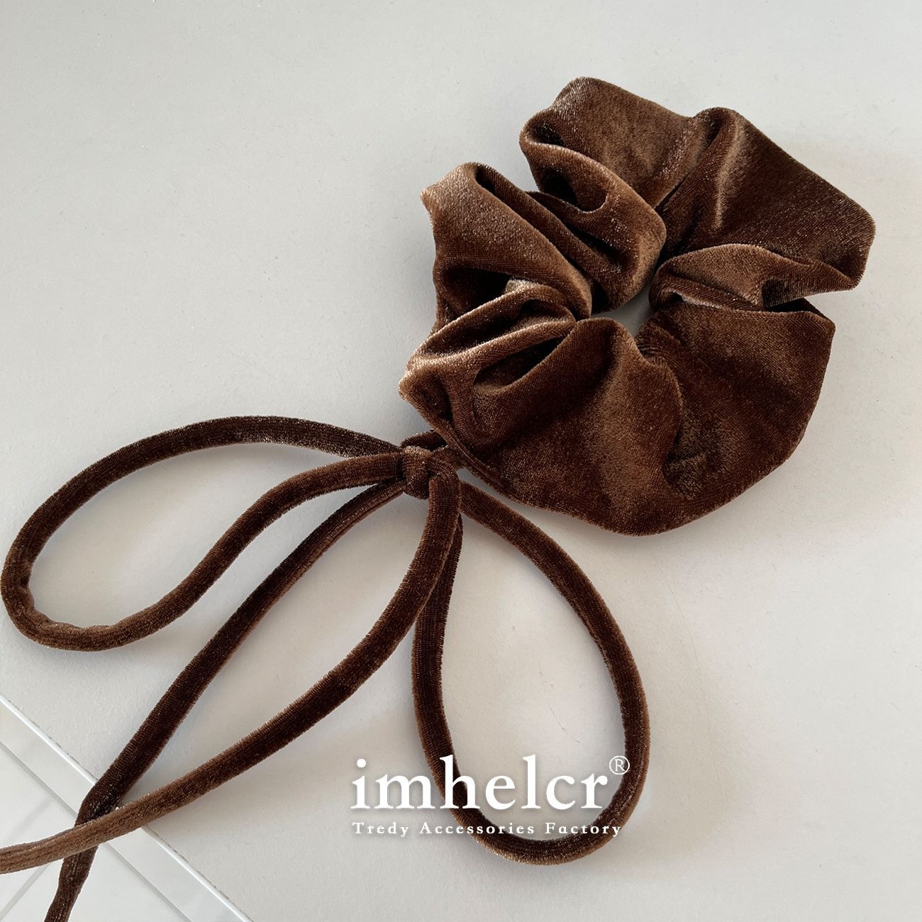 Chocolate velvet bow with long loops extending beside ponytail