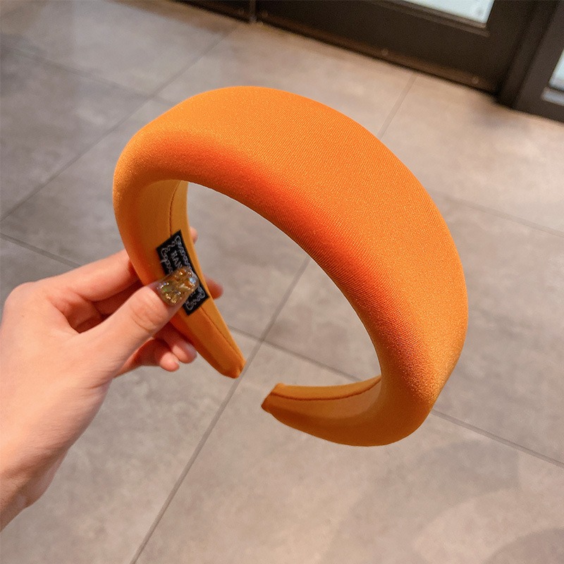 Hand showing flexible orange headband structure
