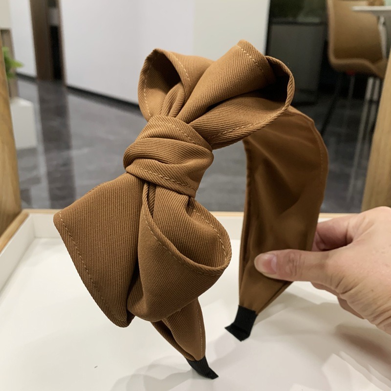 Brown bow headband showing thick padded band edge