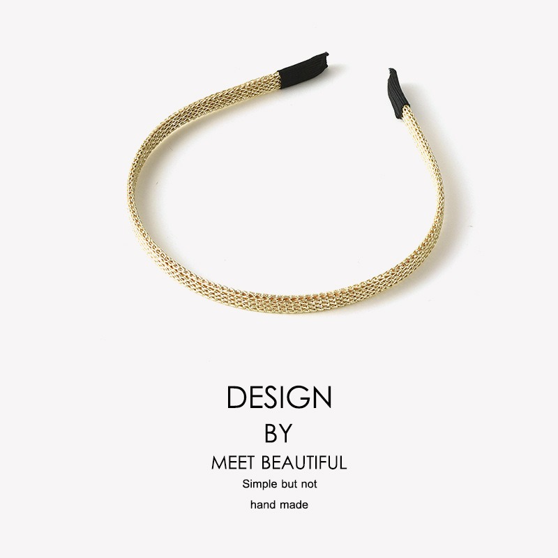 Slim spring-like gold metal clip closeup