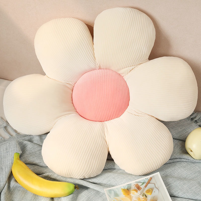 Student settling onto a soft flower cushion in a reading corner