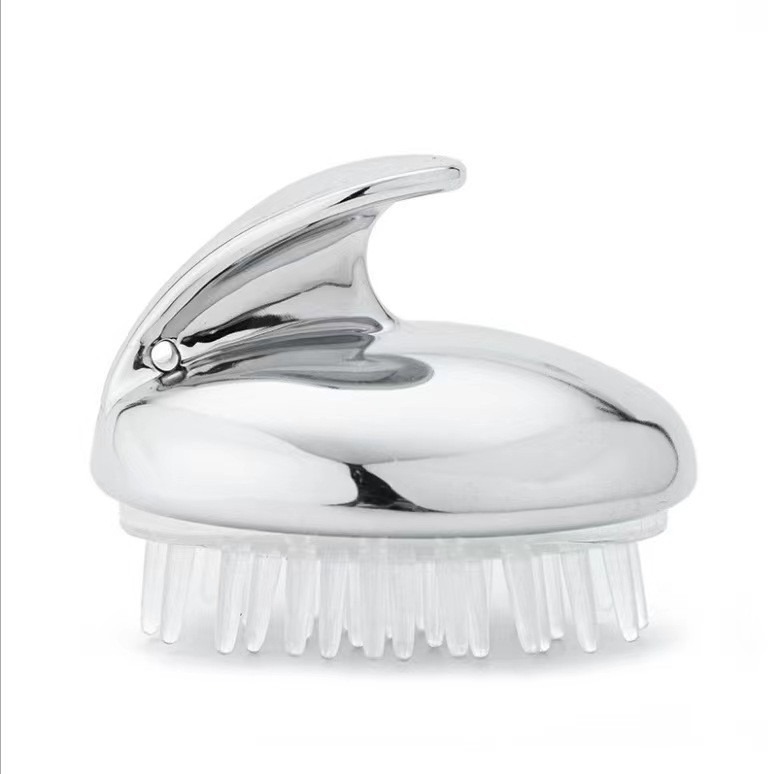 Silver chrome scalp massage brush with clear silicone bristles on white background