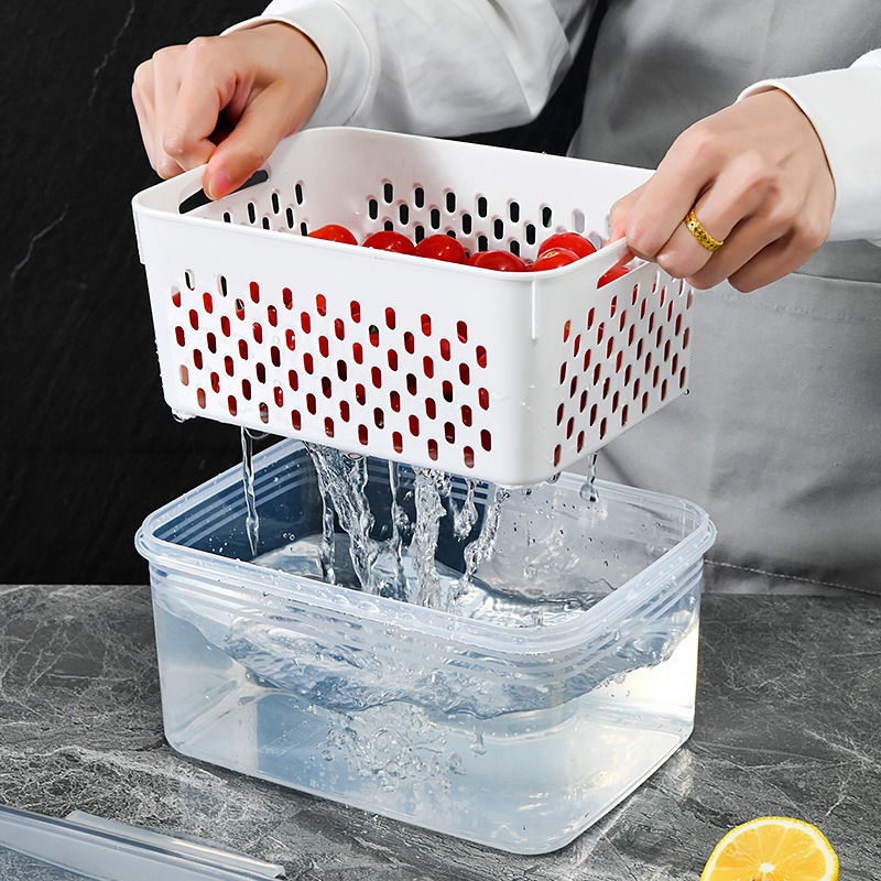 Hands lifting a perforated basket of cherry tomatoes over a base