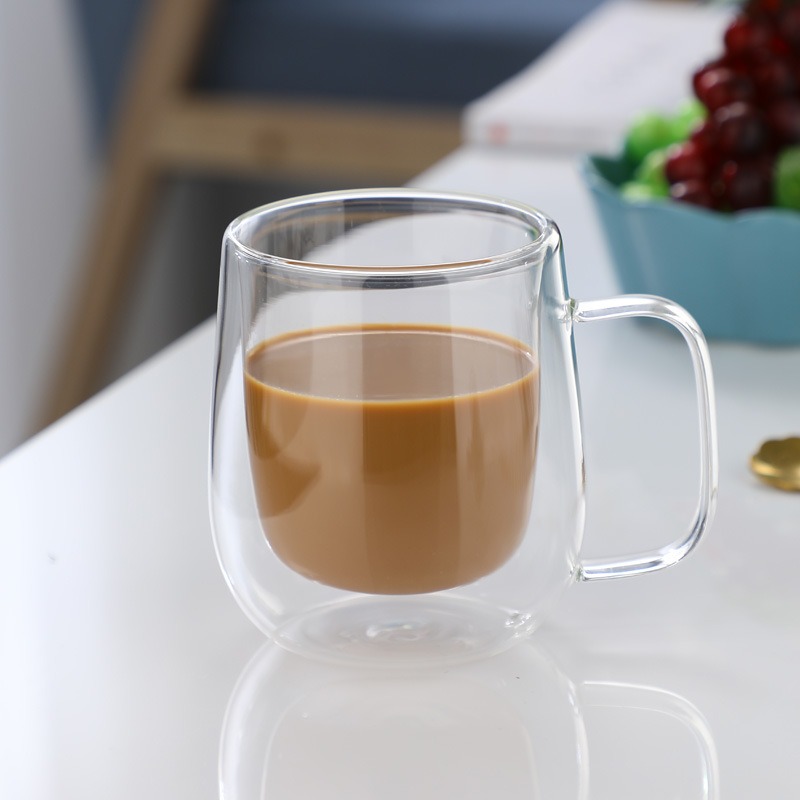 Hand gripping the C-shaped glass handle of the mug