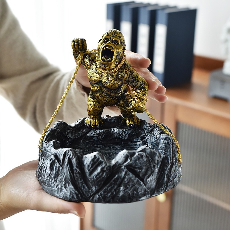 Hand holding the gorilla ashtray in front of office binders