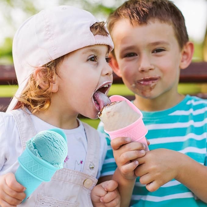 Two children eating ice cream from pink and aqua cone spoons outdoors