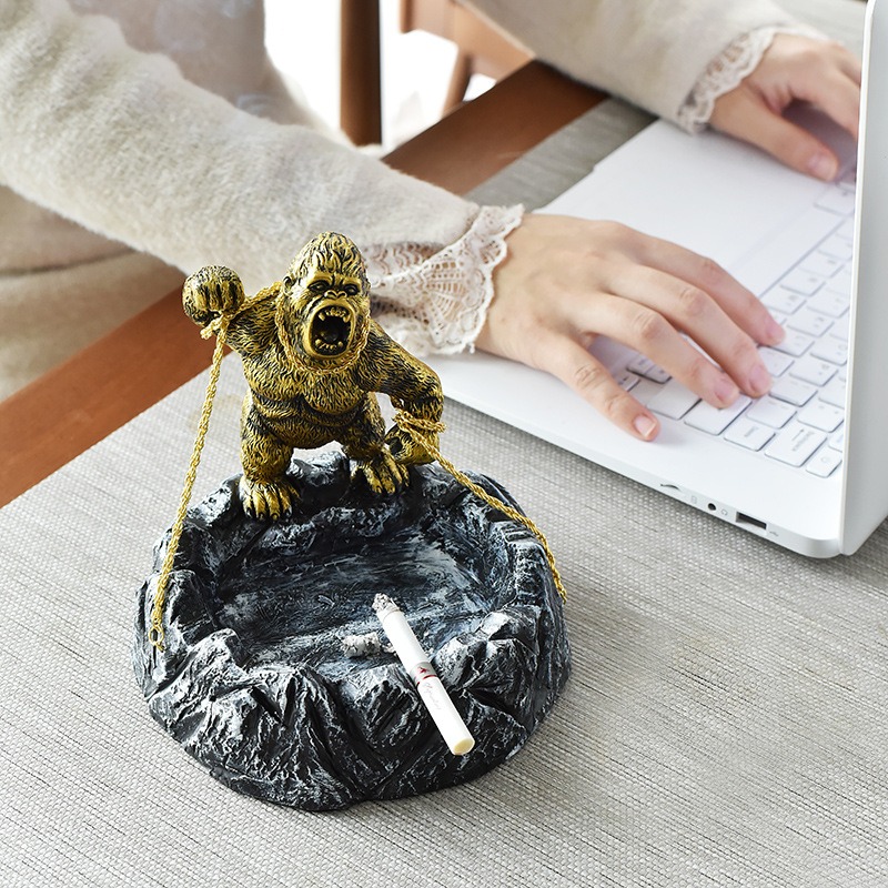 Ashtray on a desk beside a laptop and typing hands