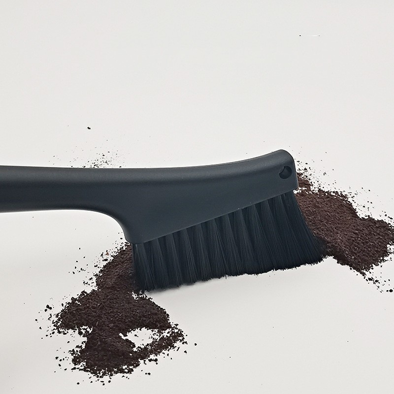 Dense angled bristles pushing coffee grounds