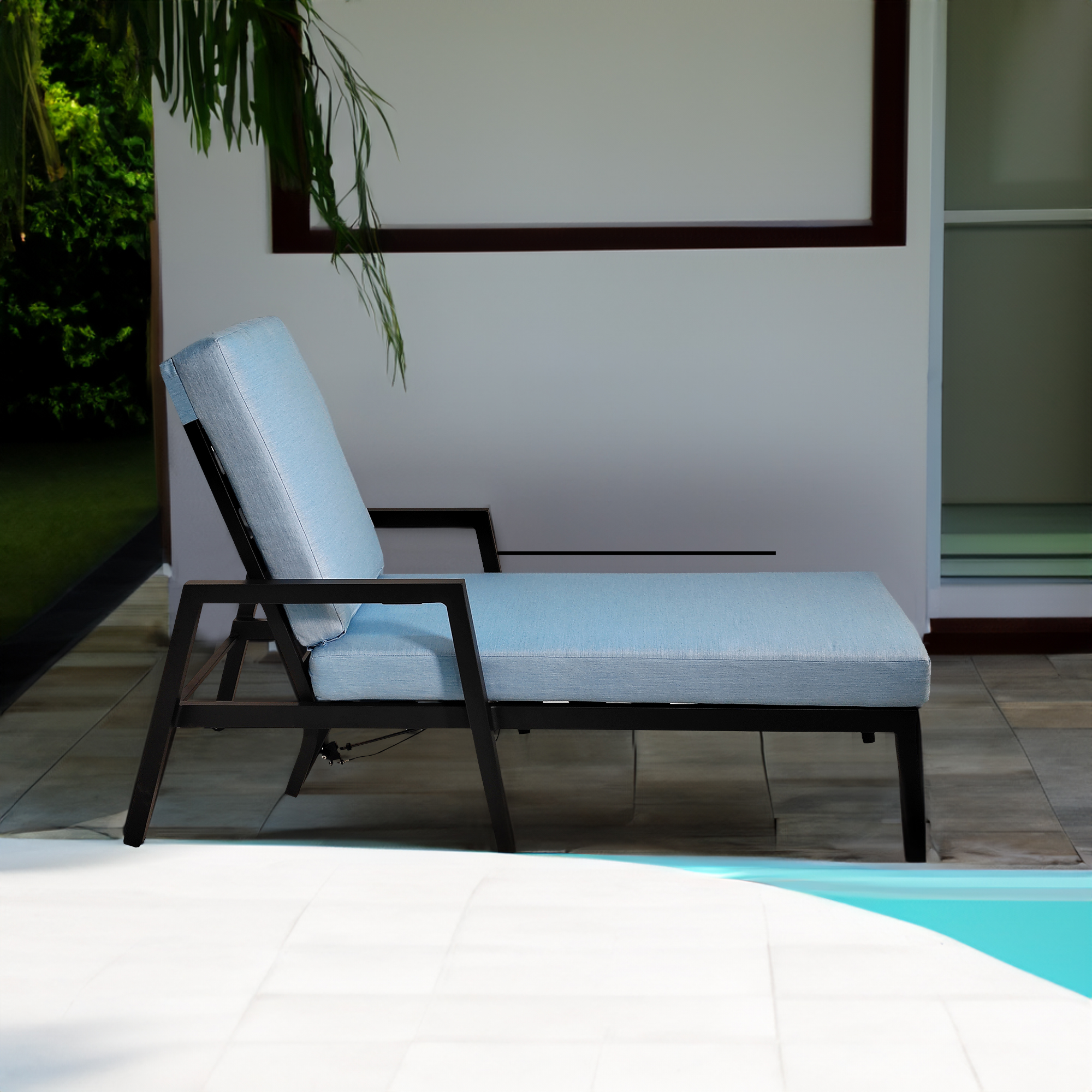 Black aluminum chaise with sky-blue cushion beside a swimming pool
