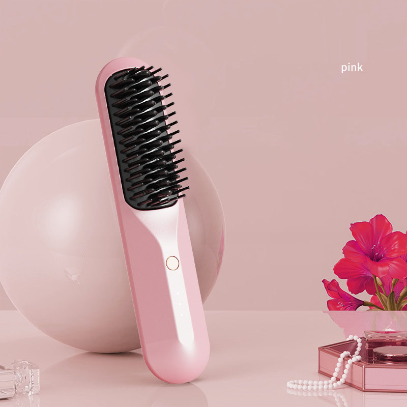 Pink portable heated comb against pink backdrop with flower and three indicator lights