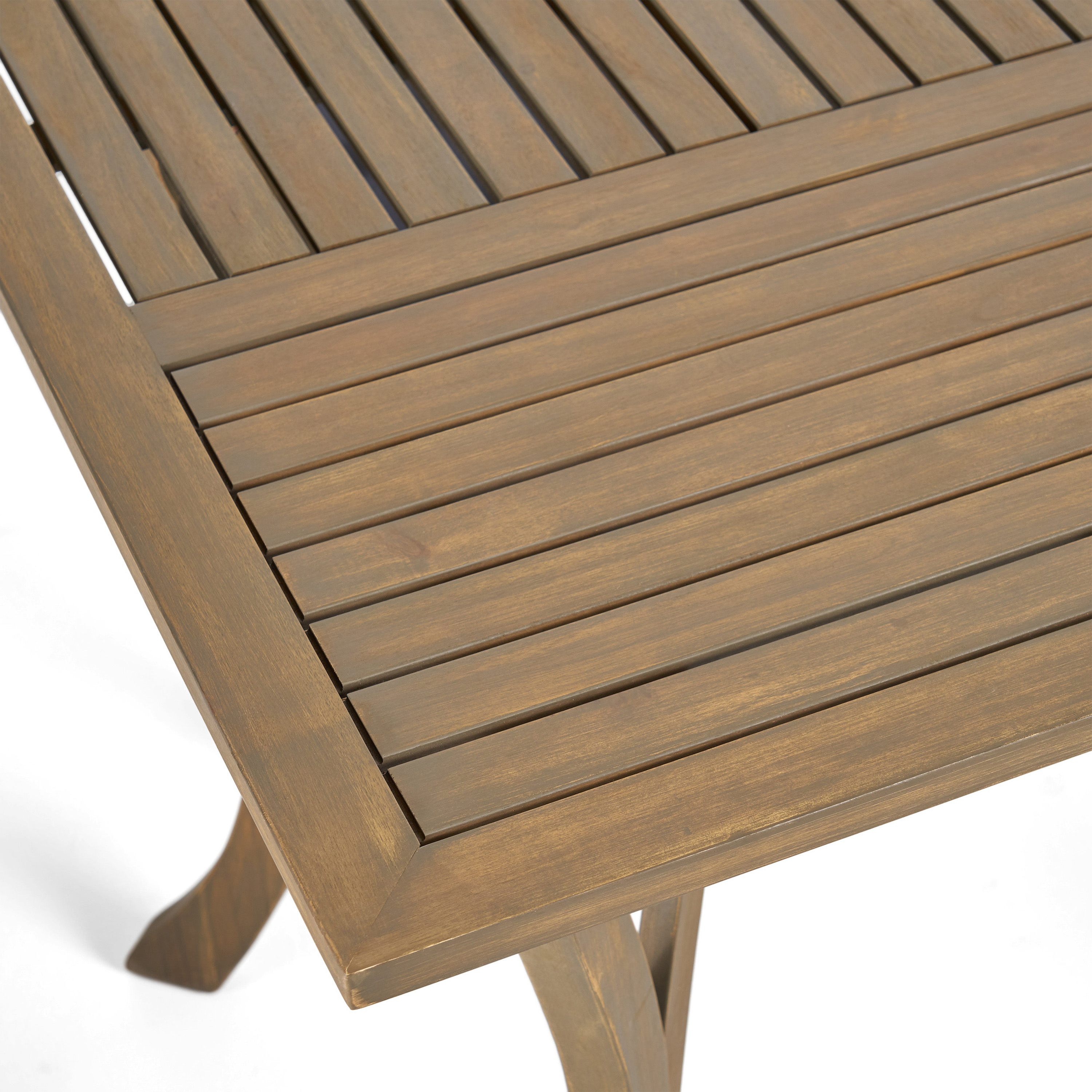Corner of the acacia table showing the slatted top and a curved leg joint