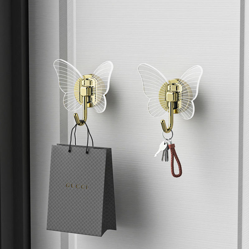 Two butterfly hooks on a light door holding a gift bag and keys
