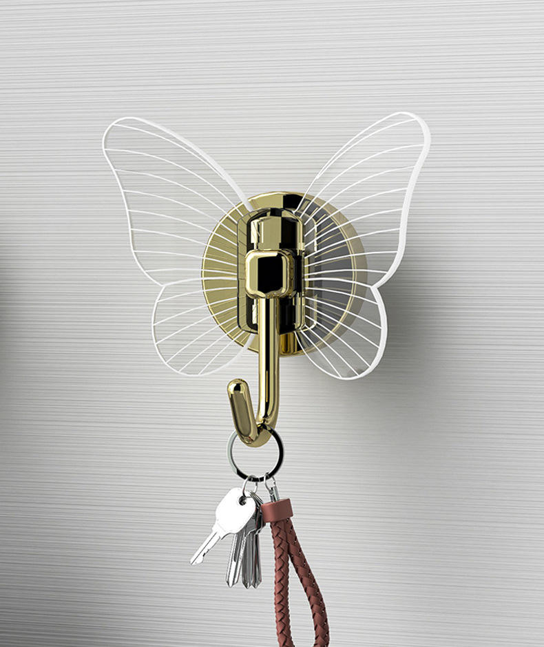 Close-up of butterfly hook holding keys on brushed metal wall