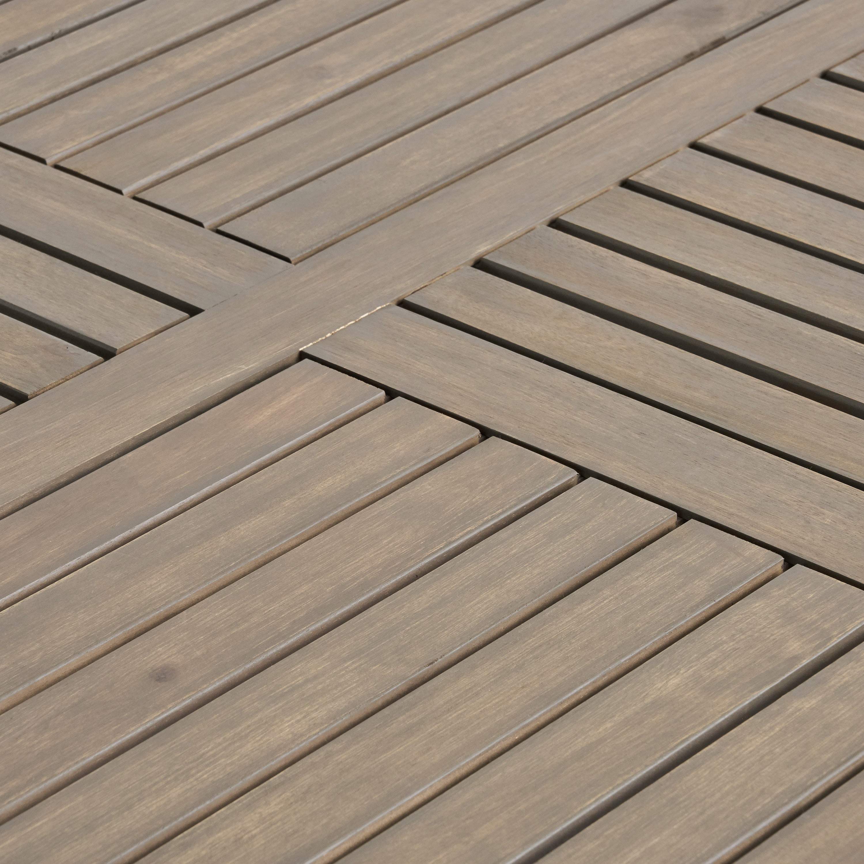 Close-up of the weathered slatted tabletop with its cross-pattern inlay