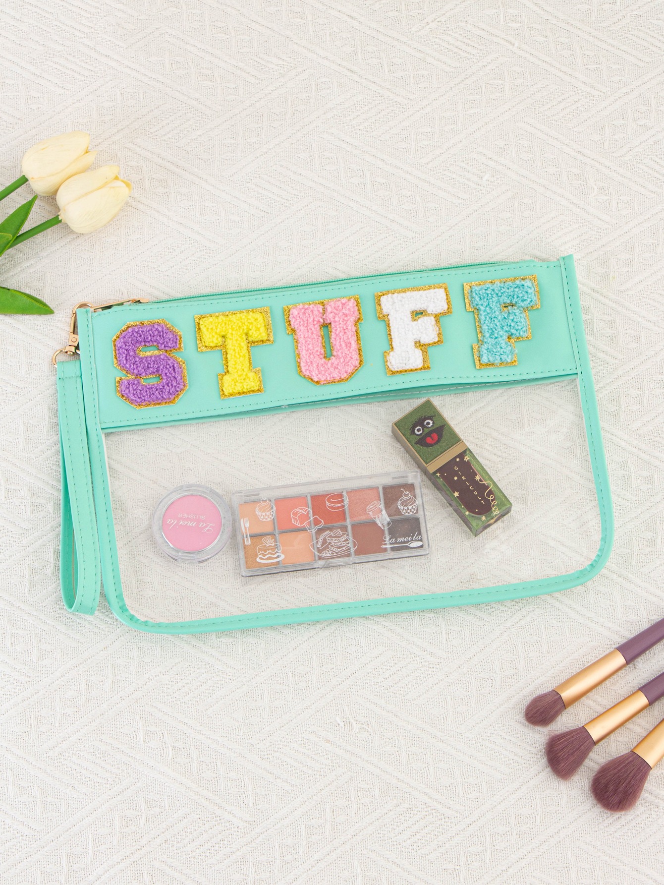 Mint clear zip pouch with chenille letters styled with makeup and brushes