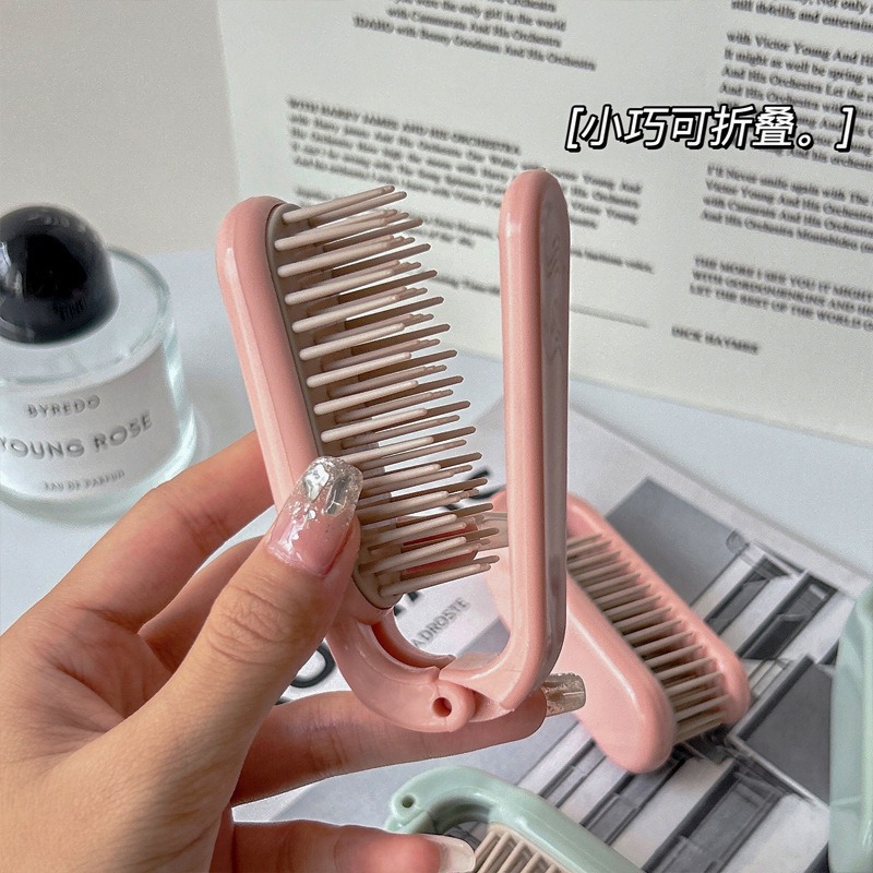 Hand holding open pink comb during a portable touch-up