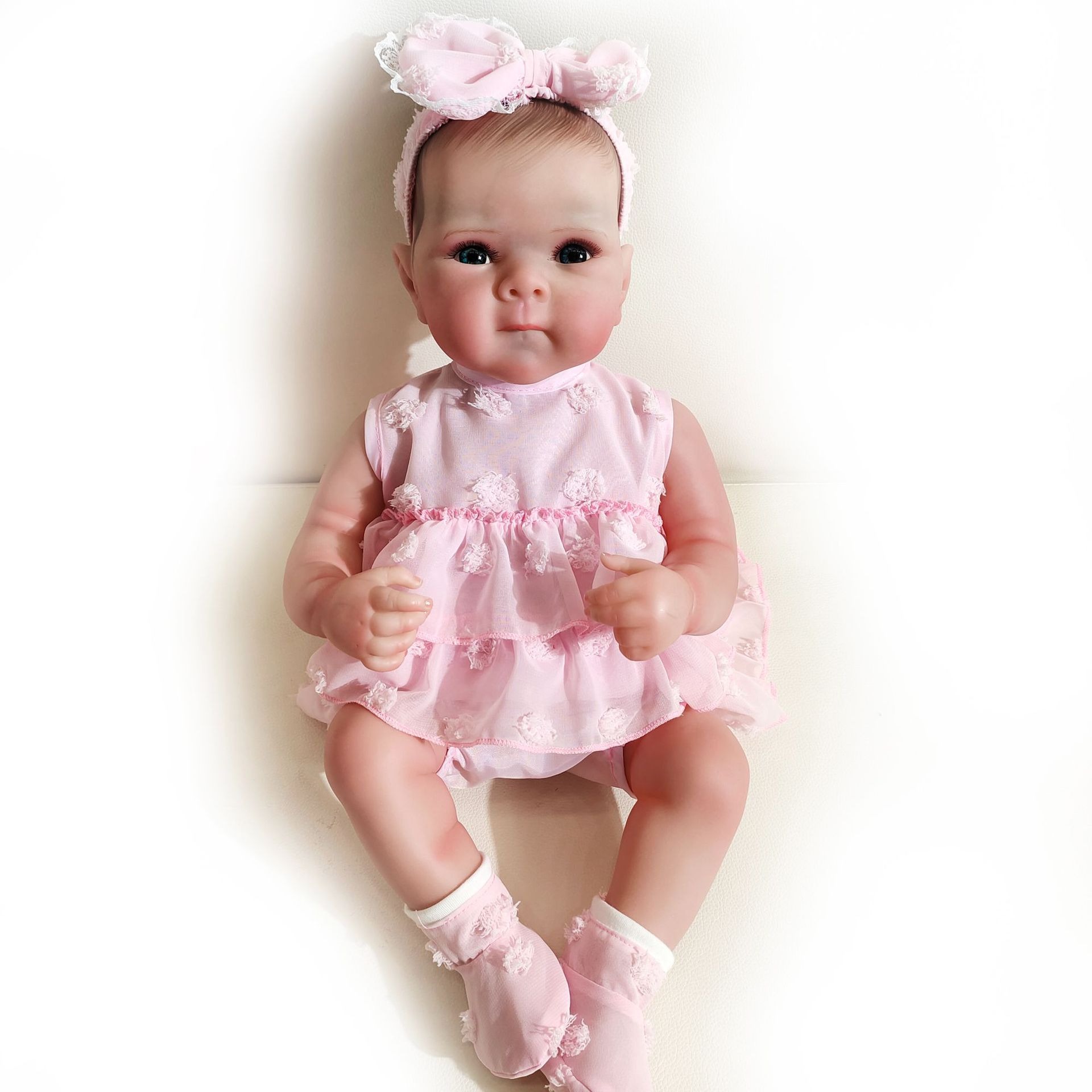 Seated reborn doll with sculpted hands