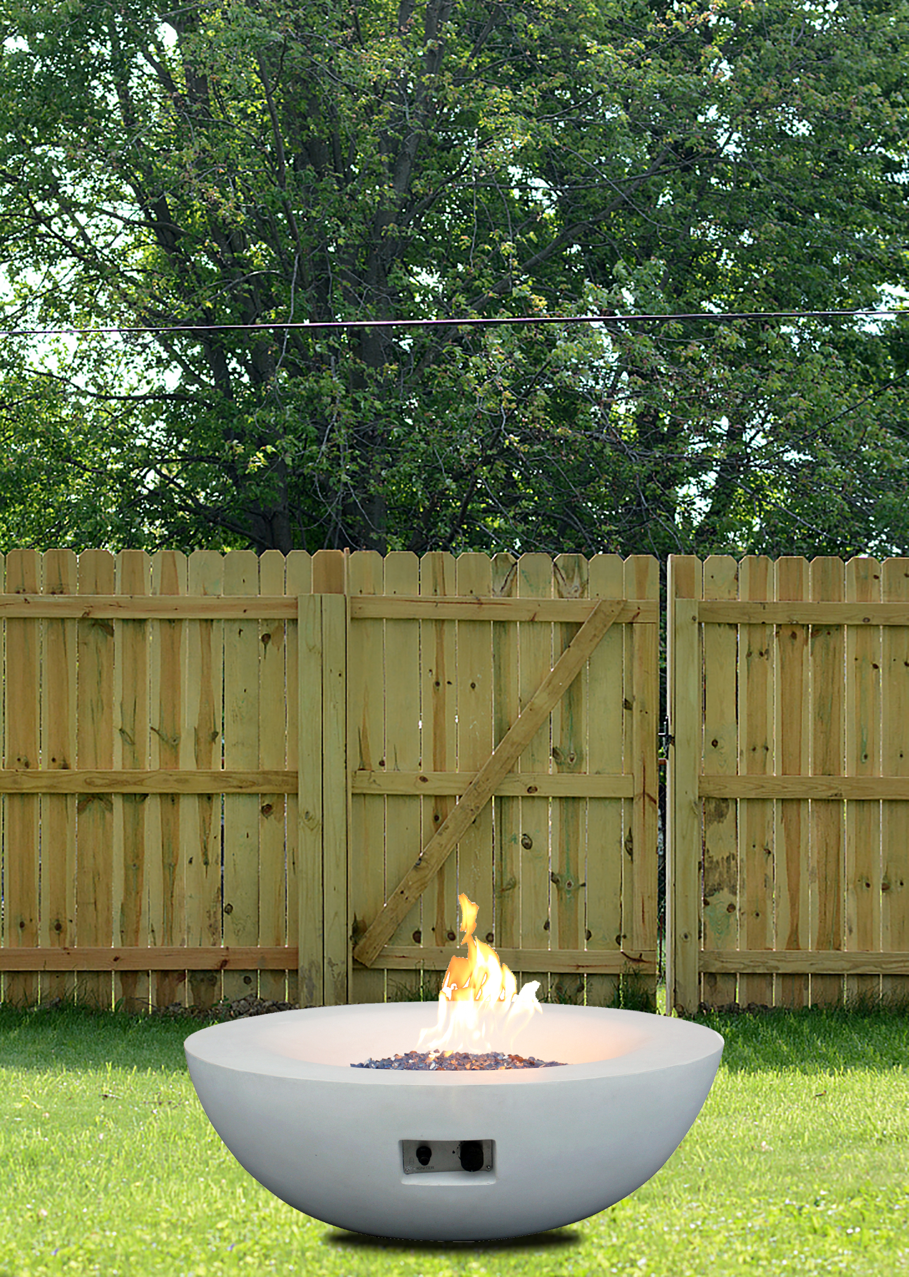 Antique white concrete fire bowl on a backyard lawn in daylight