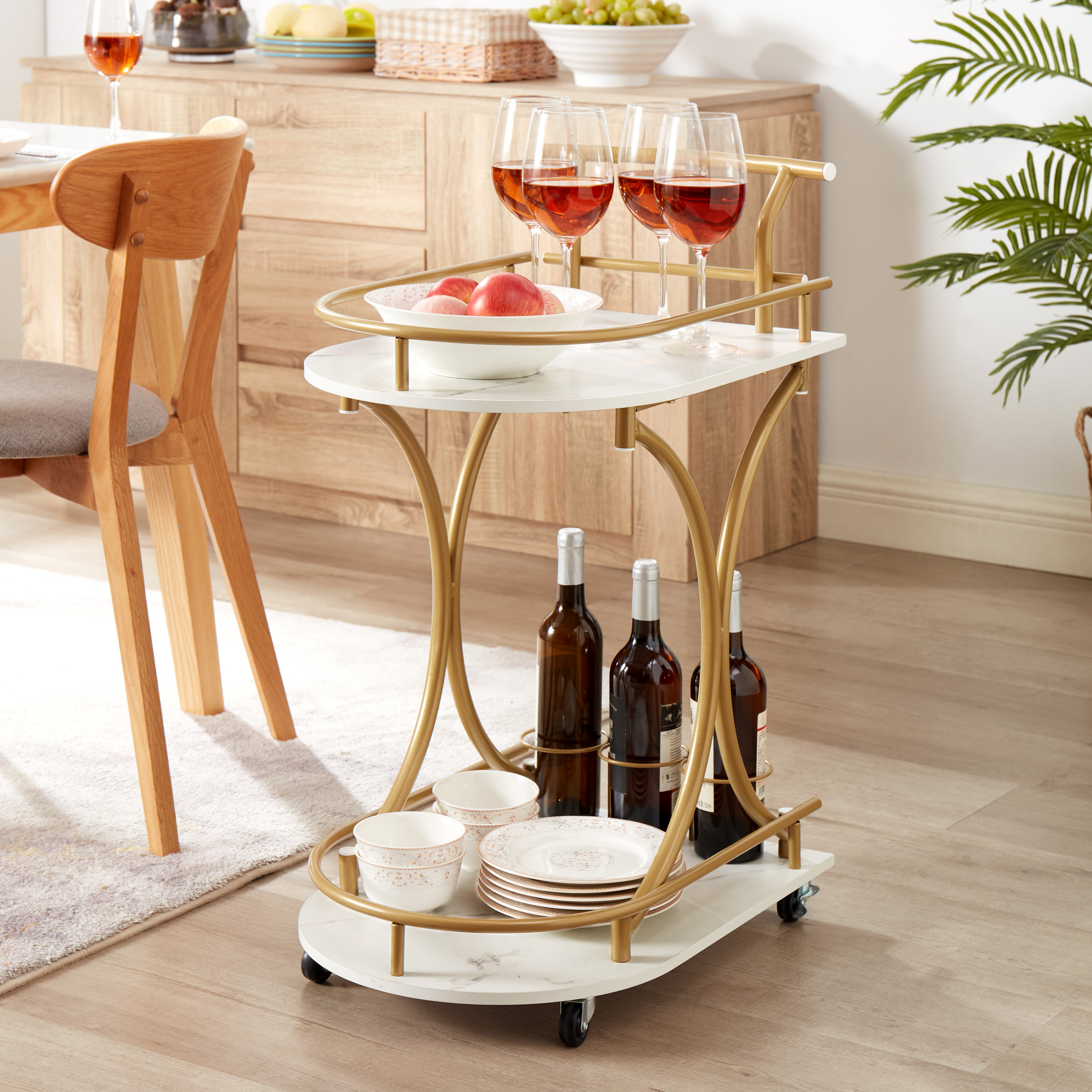 Bar cart loaded with wine bottles, stemware and fruit in a dining room