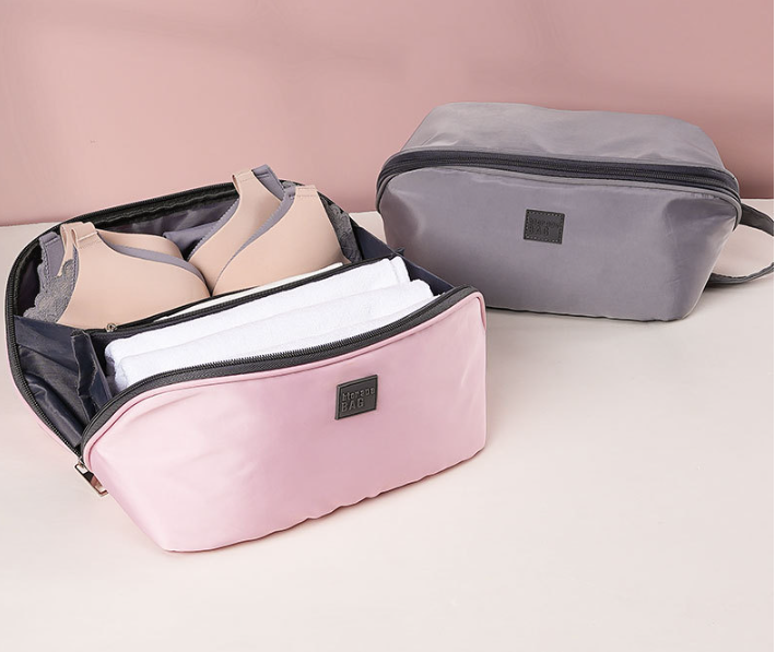 Open pink pouch with bras and folded underwear in separate sections