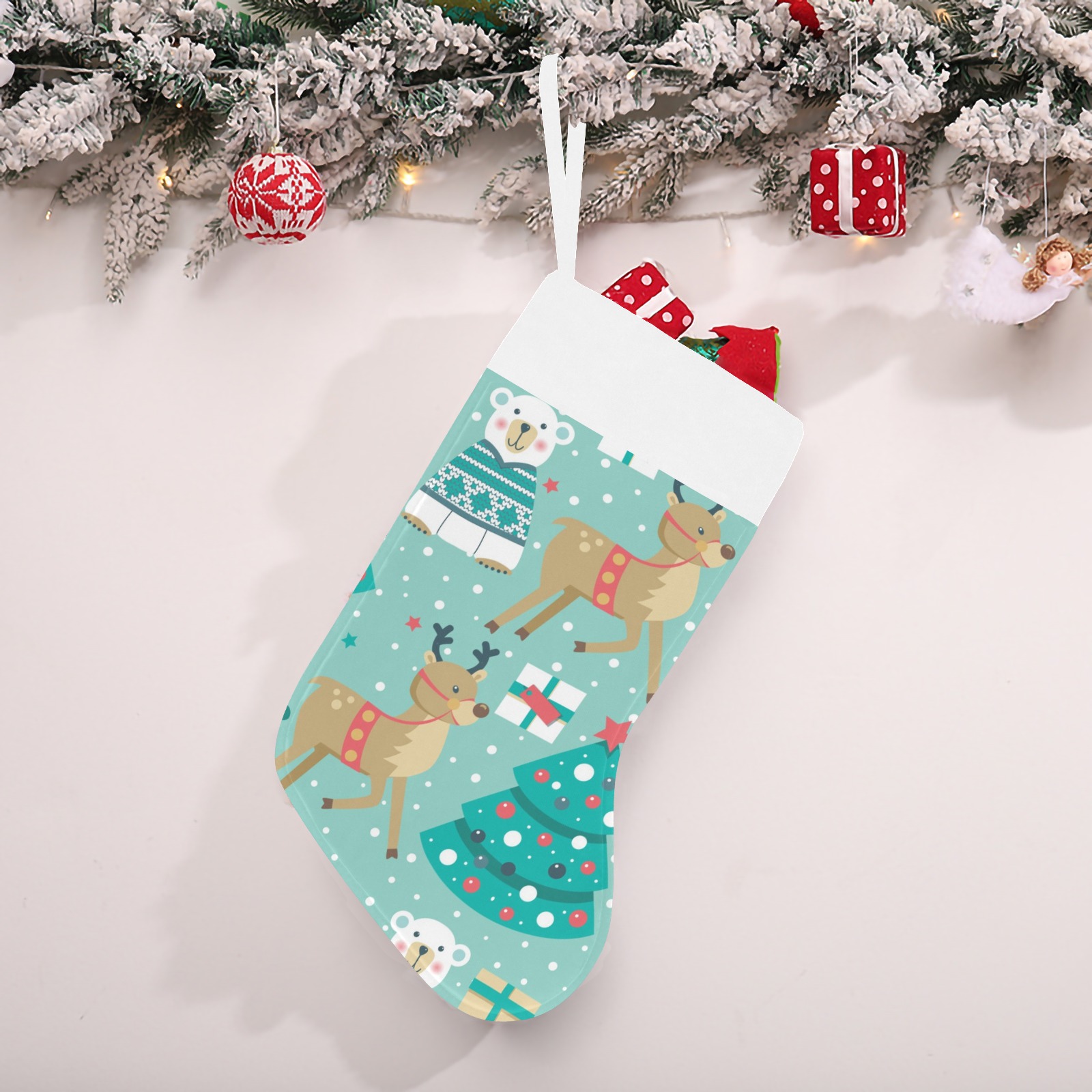 USA-made Christmas stocking with reindeer and Christmas tree pattern, hanging on a decorated branch.