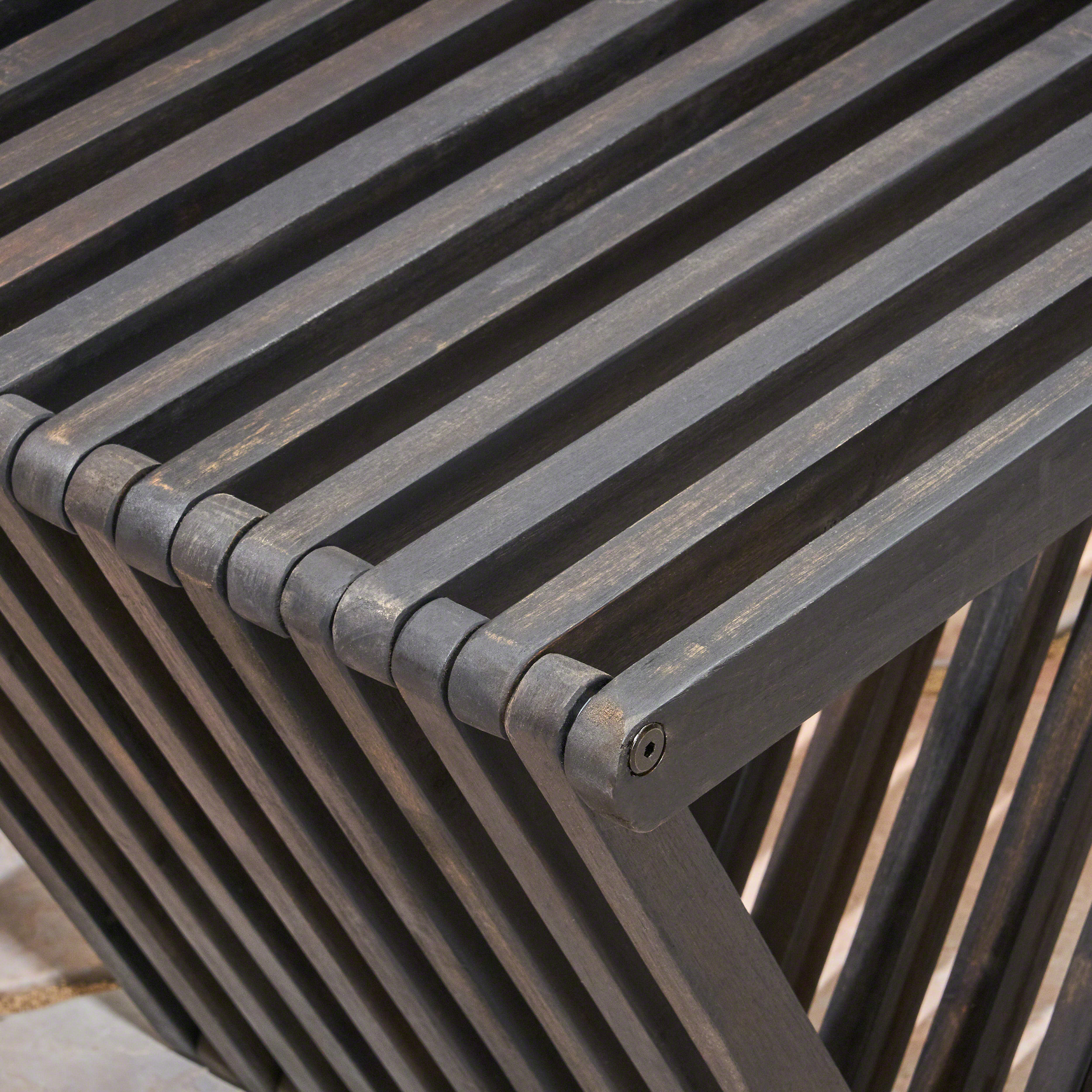 Close-up of an exposed metal fastener on a weathered wood slat