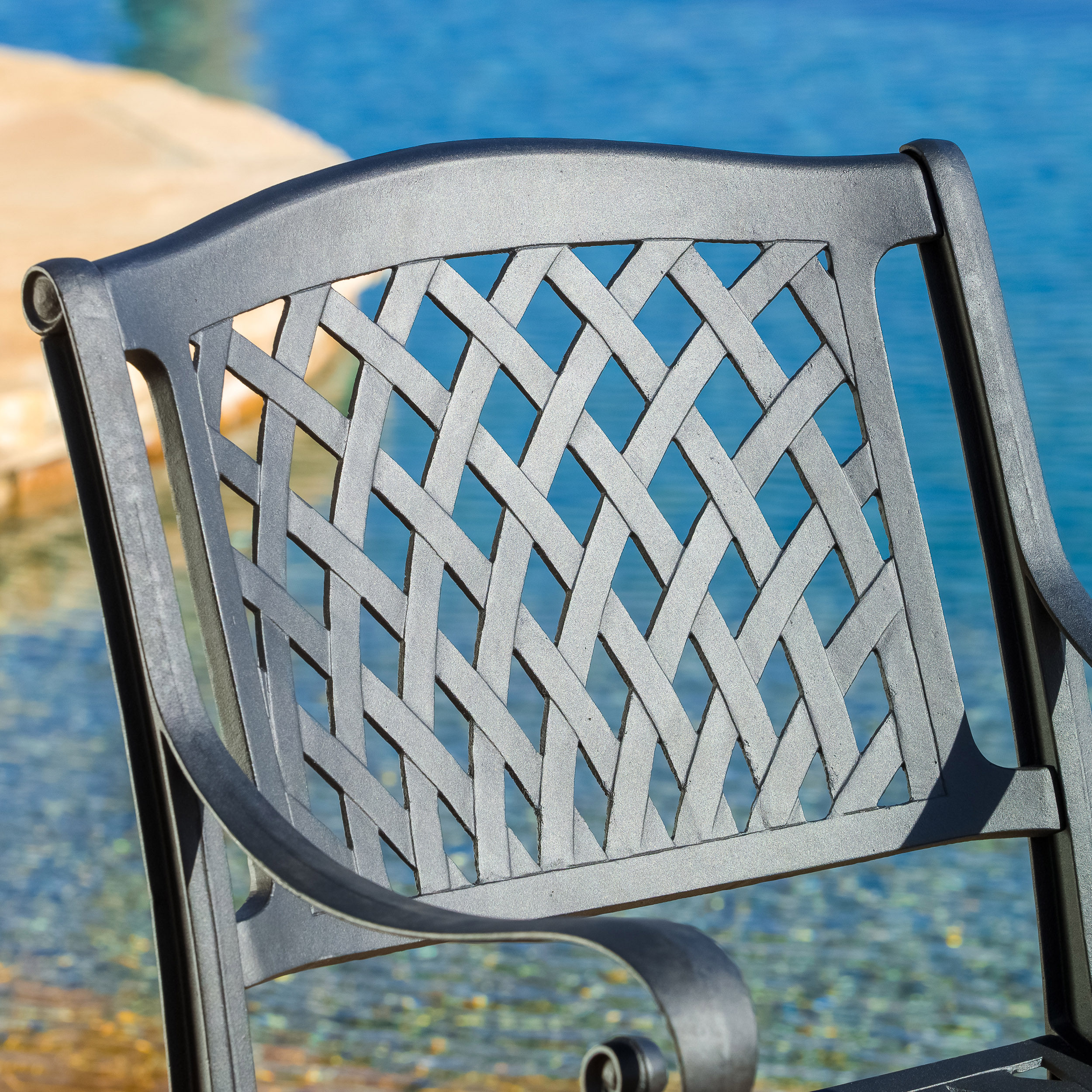 Two charcoal lattice chairs arranged for an evening dinner outdoors